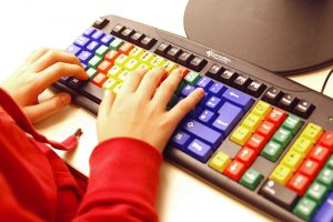 Eine Tastatur zum Erlernen des Zehnfinger-Systems. Die Tasten, die mit dem gleichen Finger betätigt werden, sind jeweils mit einer Farbe gekennzeichnet.
